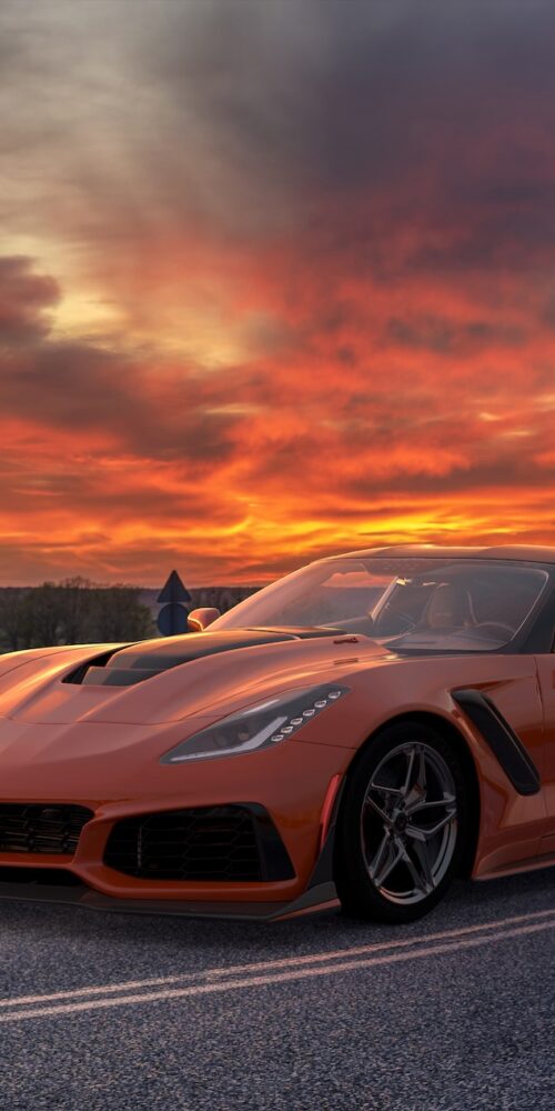 Chevrolet Corvette ZR1 with carbon fiber wheels on a curving road during sunset, showcasing high-performance design. Image used for editorial purposes.