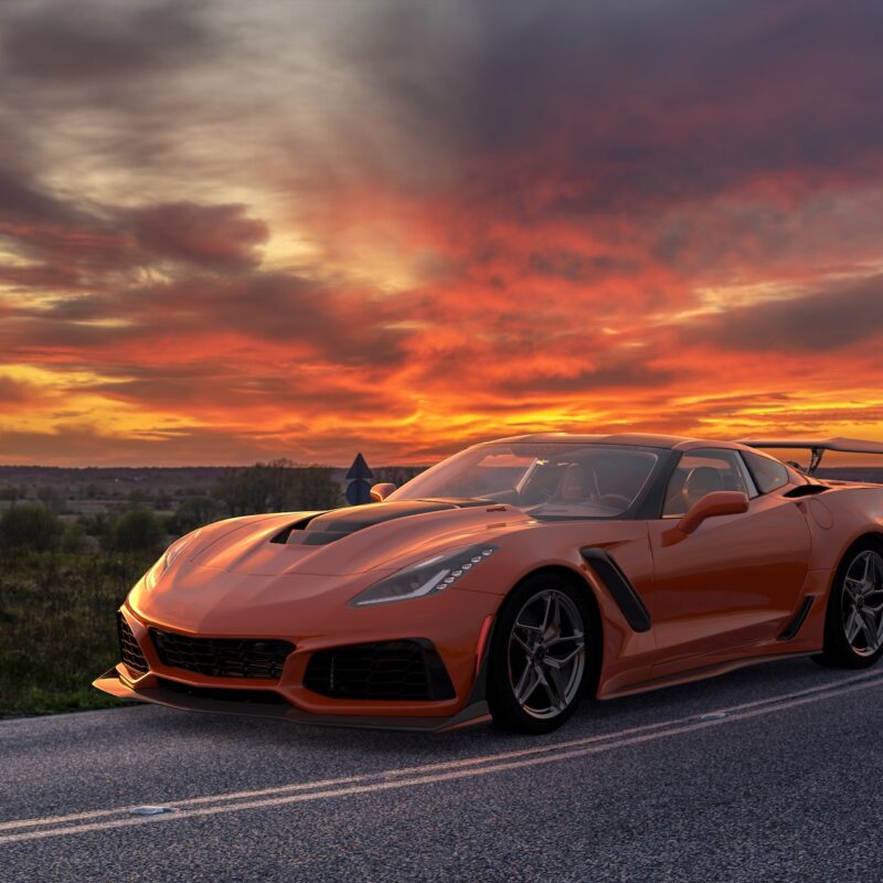 Chevrolet Corvette ZR1 with carbon fiber wheels on a curving road during sunset, showcasing high-performance design. Image used for editorial purposes.