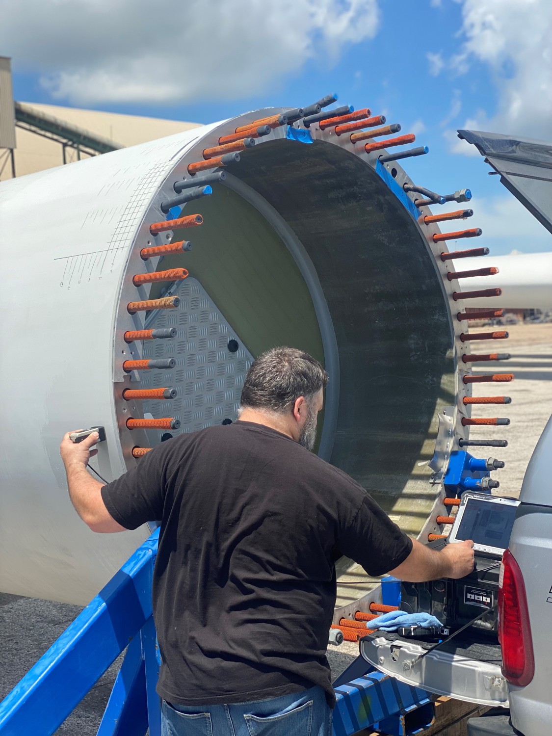 CEO Jeremy Heinks performing ultrasonic testing (UT) on a wind turbine blade root section to inspect for defects.